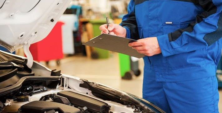 Technician writing up a vehicle check on a clipboard