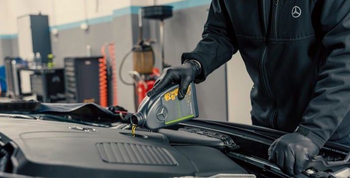 Technician pouring fresh oil into an engine