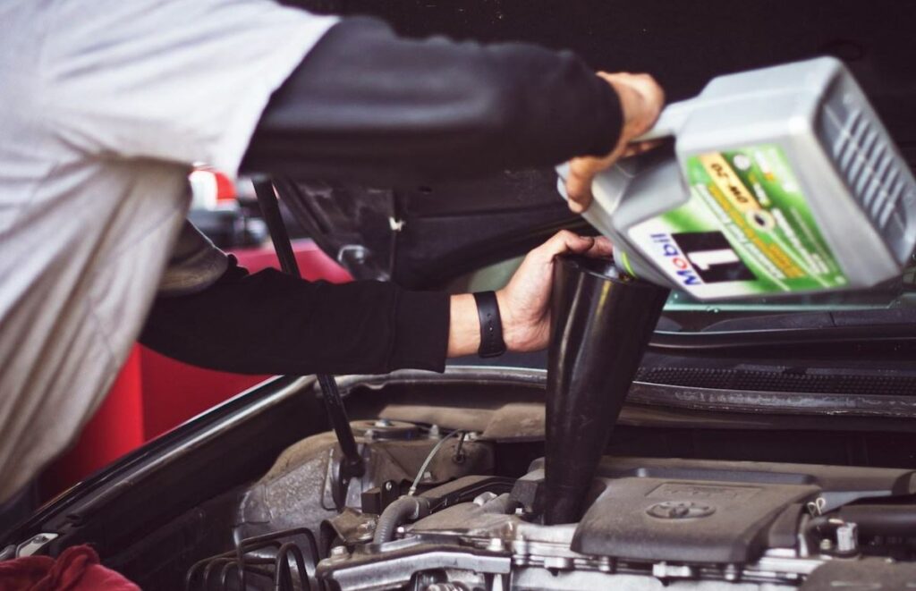 Fresh motor oil being poured into an engine